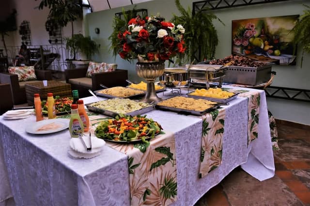 Mesa de buffet enfeitada com um grande arranjo de rosas vermelhas